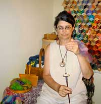 Woman demonstrating spinning thread